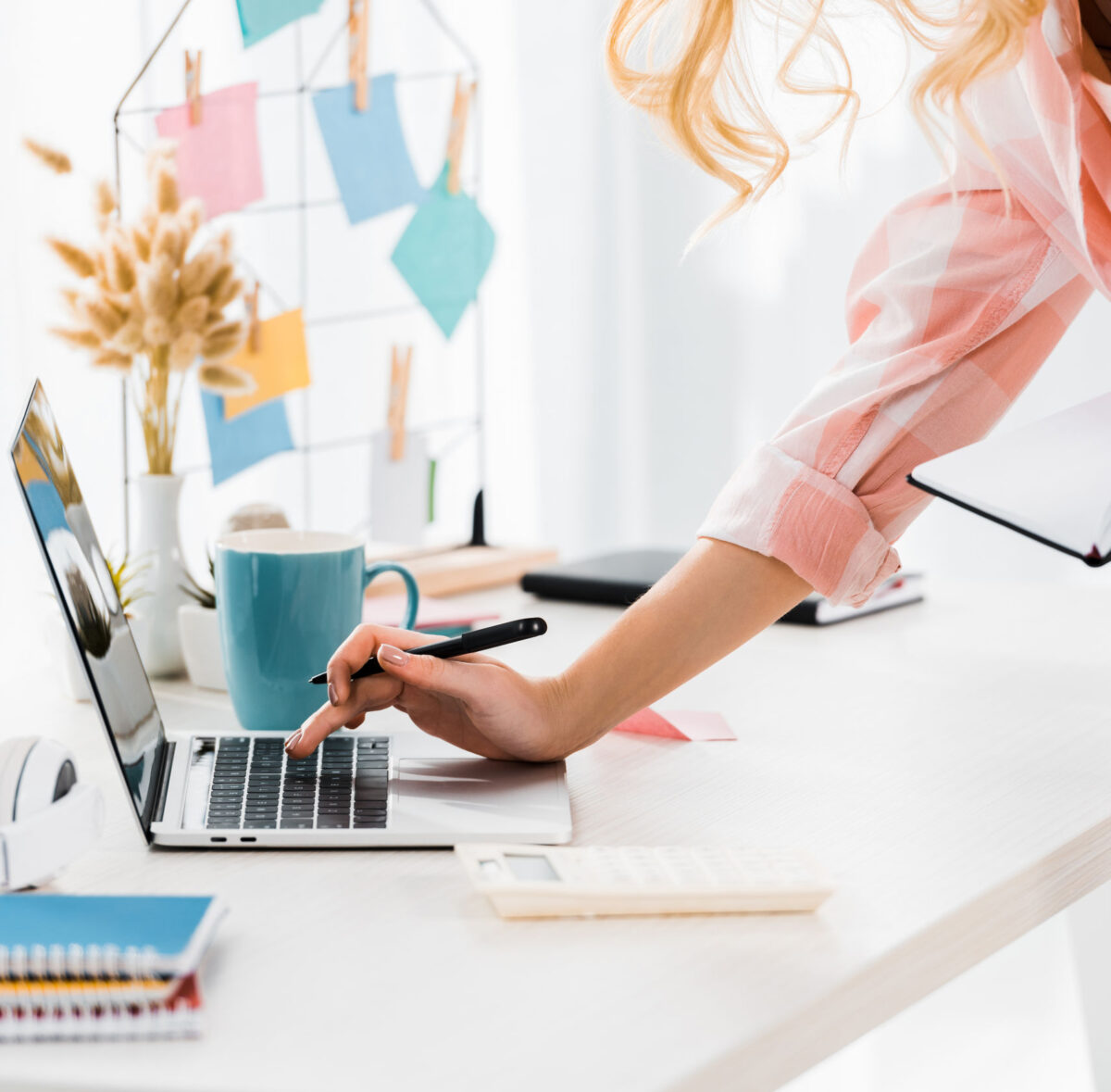 Don't waste time doing your own books, use our outsourced bookkeeping service instead! Image of a woman using a laptop, illustrating a page about bookkeeping.