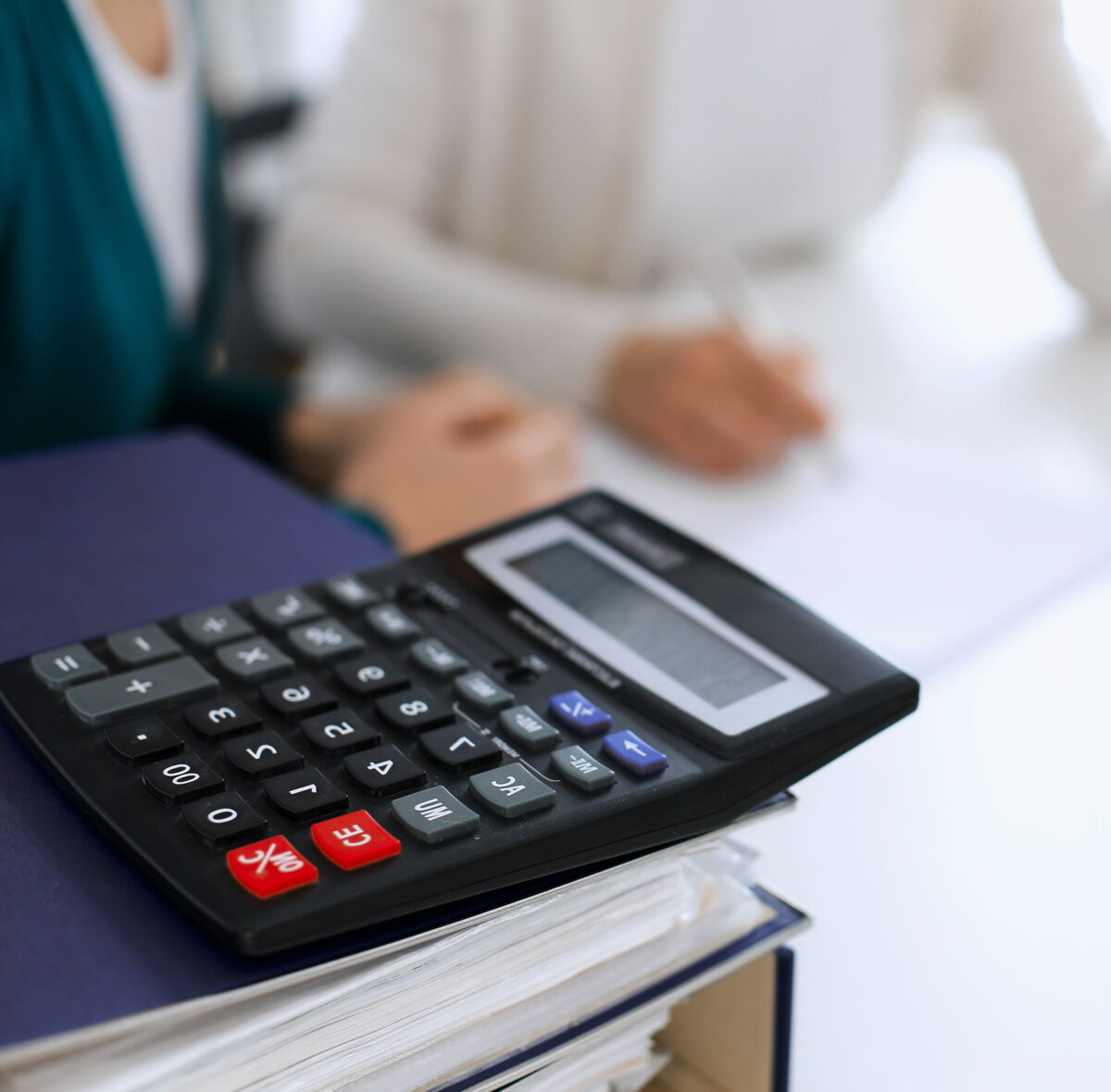 When you use our bookkeeping service, you'll have more time to focus on your business. An image of a calculator and binders to illustrate a page about bookkeeping services.