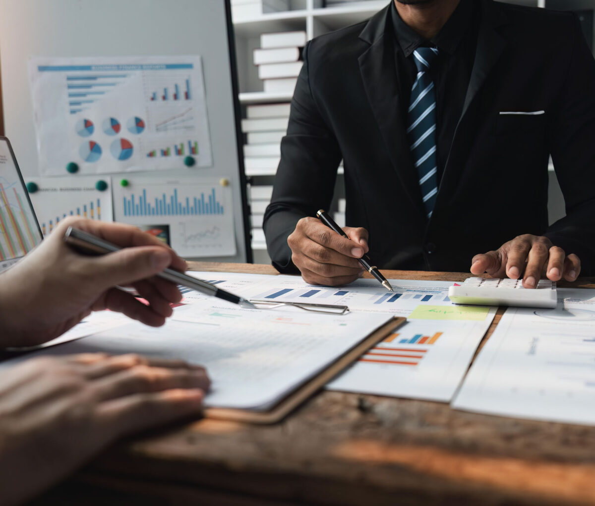 We offer on-site or remote bookkeeping or both. An image of two business people working on financial figures, illustrating a bookkeeping service page.