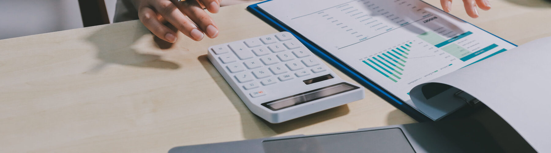 Image of a woman using a calculator to calculate figures, illustrating a Bookkeeping service page.