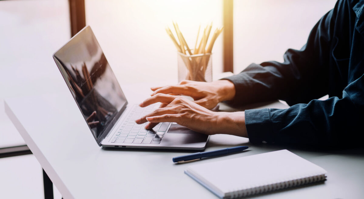 Ask us how our paryoll outsourcing service works. Image of someone's hands using a laptop to illustrate an article on payroll outsourcing.
