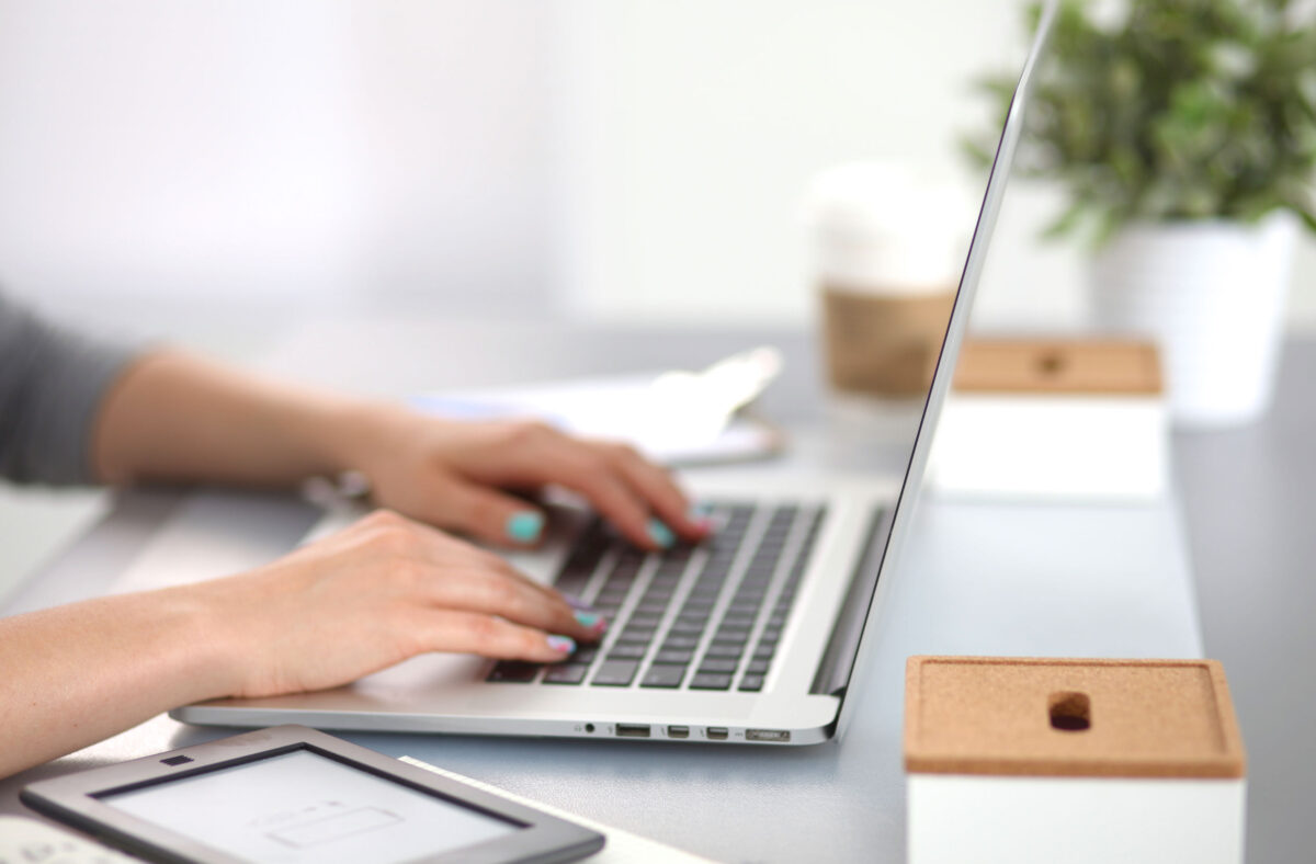 Our payroll outsourcing service frees up time that you can invest in your business's growth Photo of someone working on a laptop, processing a payroll.
