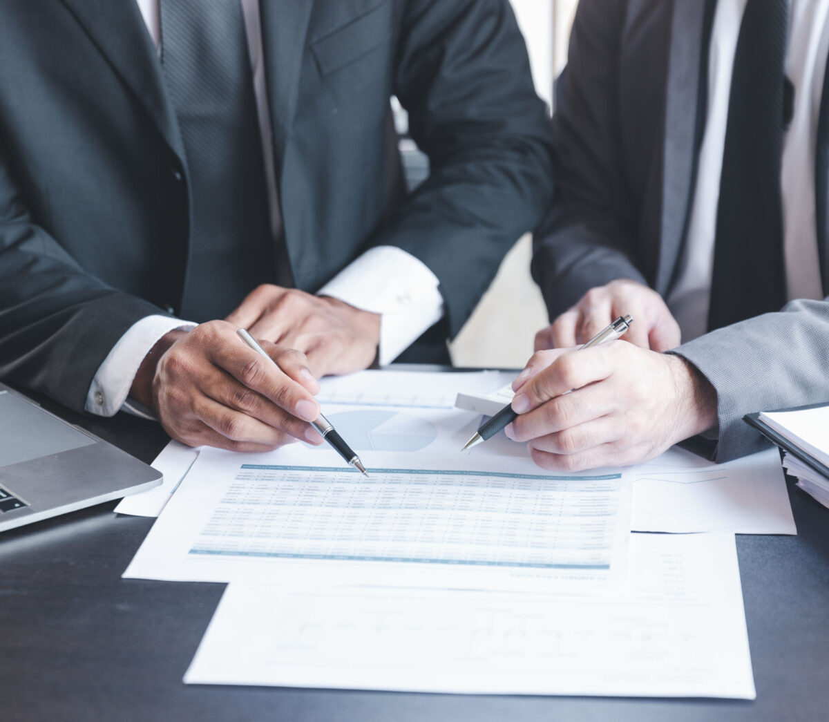 We can provide grant audits for a range of different funders. Image of two business men working on paperwork together.