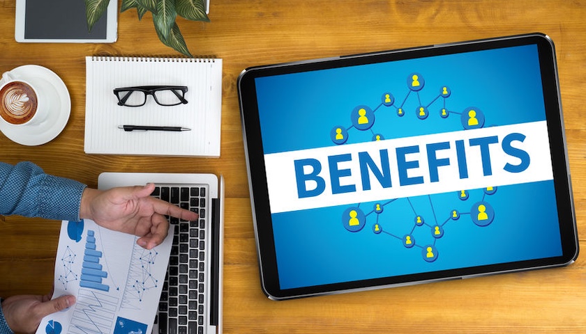 The word 'BENEFITS' displayed on a tablet, illustrating an article on the mandatory payrolling of benefits.
