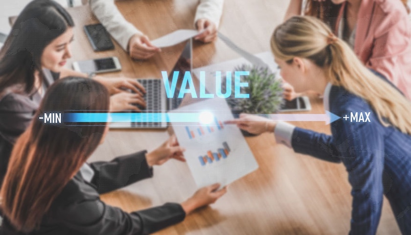 The word value on a sliding scale, added to a pic of businesswomen looking at financial charts. This illustrates an article that explains how to increase business value.