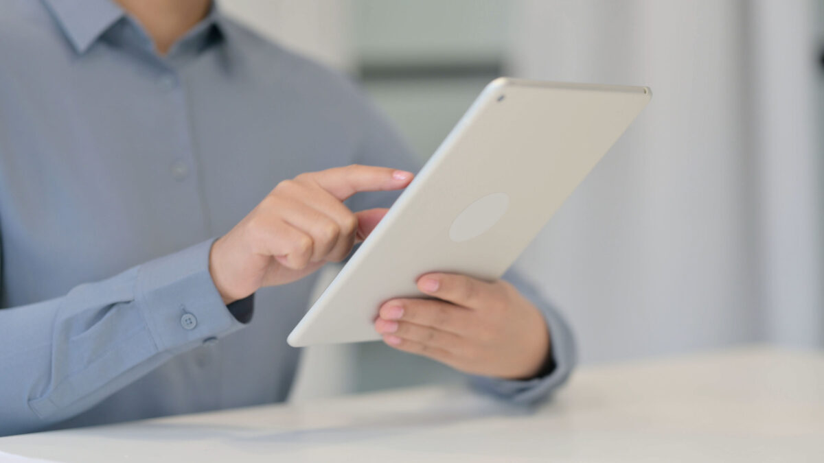 An image of a person using a tablet, illustrating a page about Making Tax Digital