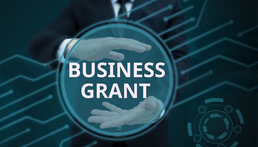 A graphic concept of hands encircling the words BUSINESS GRANT - to illustrate an article on Innovate UK Cost Guidance.
