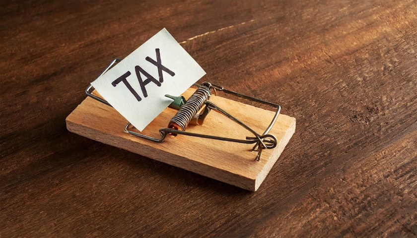 A photo of a mouse trap with a post-it note reading 'TAX' stuck on it - to illustrate an article on the 60% tax trap