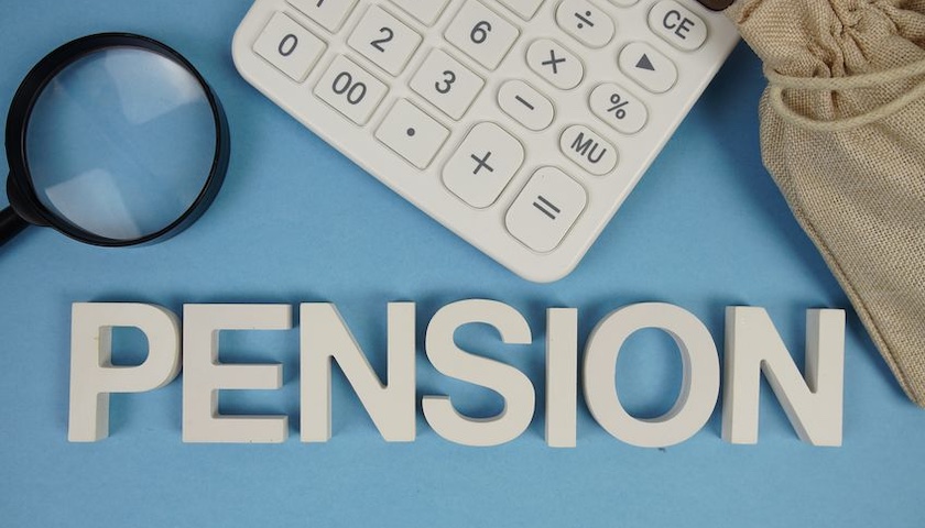 Pension alphabet letters with magnifying glass and calculator on blue background - illustrating an article on missing Child Benefit credits