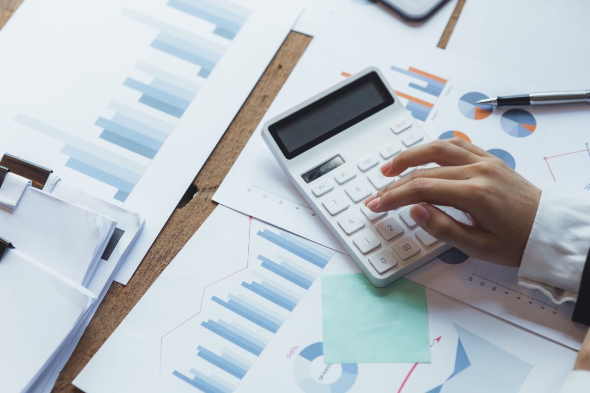 Image of a hand, calculator and printed financial pages - to illustrate a section on what tax planning services can help with.