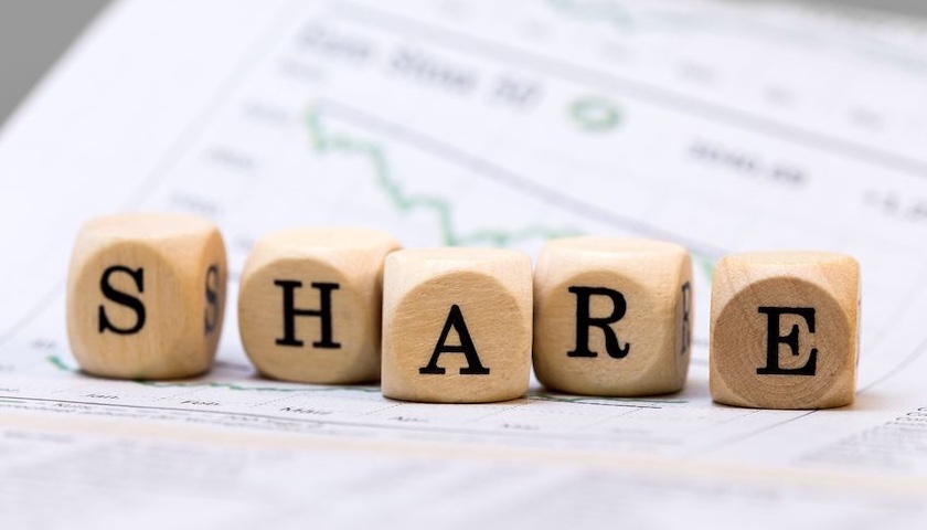 Wooden blocks on a graph spelling out the word SHARE, to illustrate an article on EMI share options
