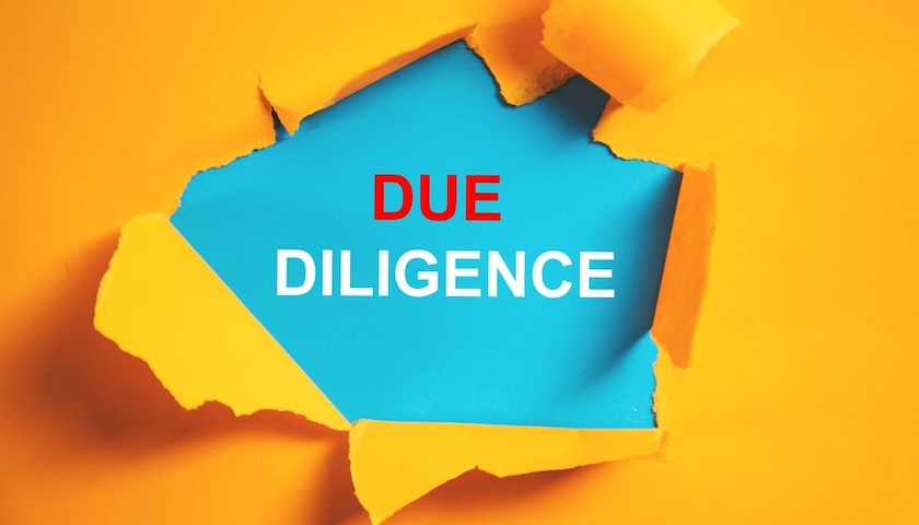 Image of the words DUE DILIGENCE revealed by a hole in ripped paper, illustrating an article on vendor financial due diligence.