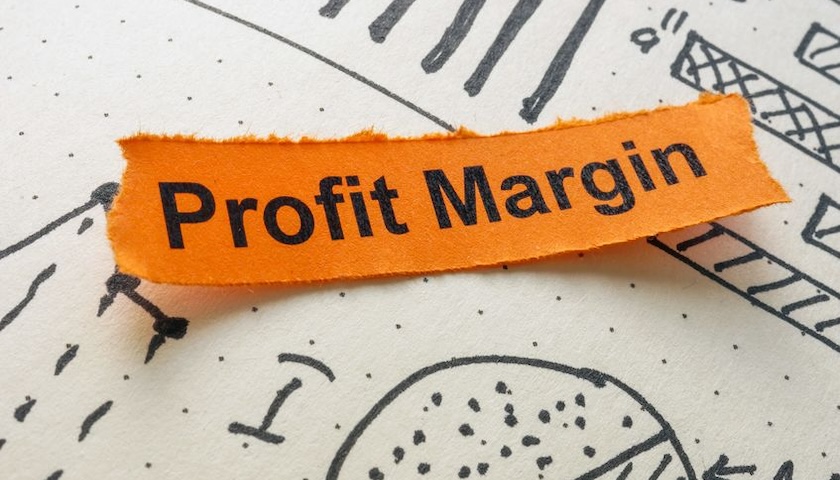 Image of the words 'Profit Margin' on a slip of paper, placed on top of some drawn charts - illustrating a piece on how to improve profit margin