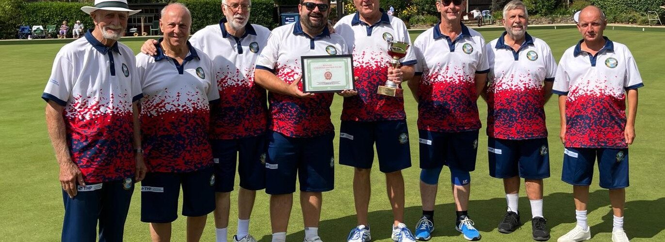 Photograph of Aldersbrook Bowls Club wearing THP sponsored kit and with some members holding trophies.